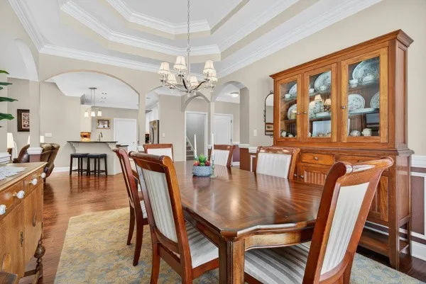 a dining room with furniture a chandelier and wooden floor