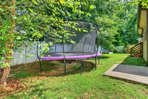 a view of a house with backyard and trees