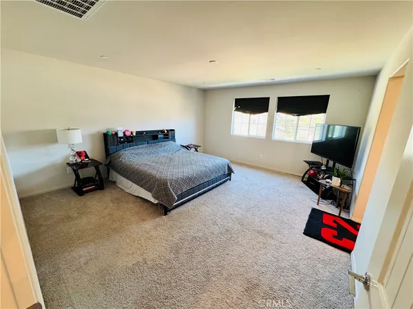 a bedroom with furniture and a flat screen tv