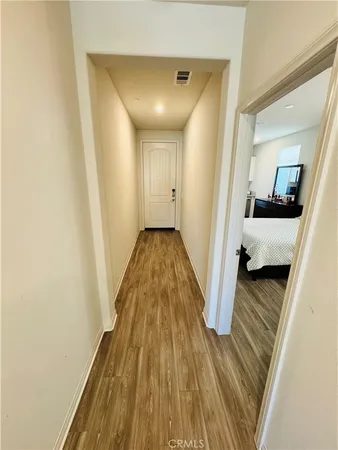 a view of a hallway with wooden floor and closet