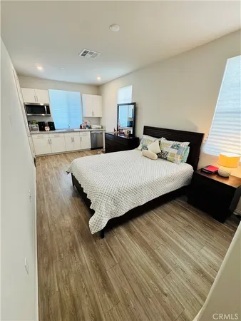 a bedroom with a bed and a view of kitchen