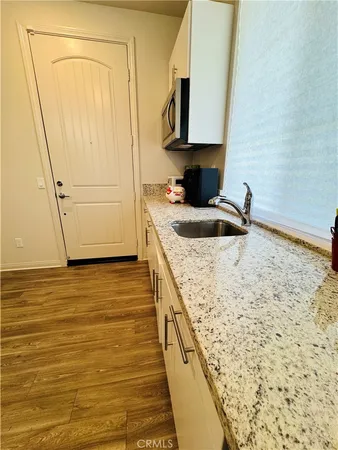 a kitchen with granite countertop sink and cabinets