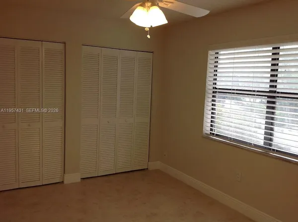 a view of a livingroom with a chandelier fan and a window