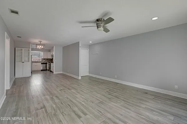a view of empty room with wooden floor
