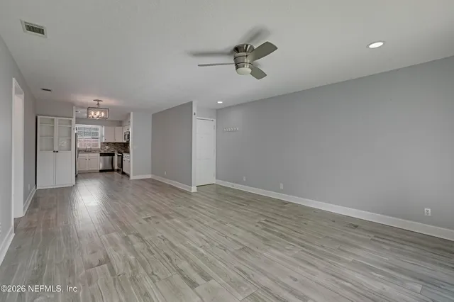 a view of empty room with wooden floor