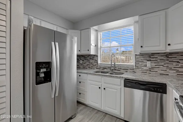 a kitchen with stainless steel appliances granite countertop a refrigerator and a sink
