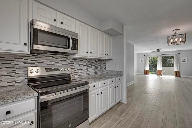 a kitchen with stainless steel appliances a stove microwave and cabinets