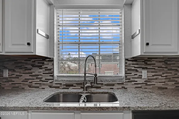 a kitchen sink with granite countertop a sink and a window