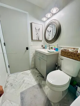 a bathroom with a toilet a sink and a mirror