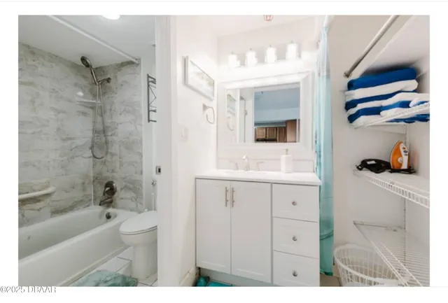 a bedroom with a bed a couch and large window