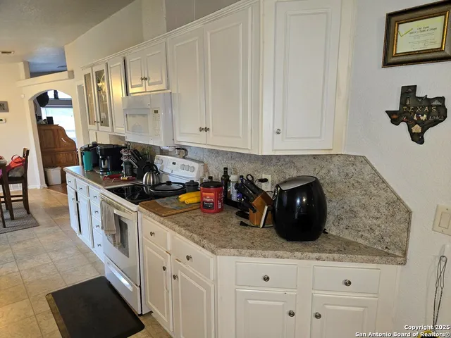 a kitchen with stainless steel appliances granite countertop a sink a stove and cabinets