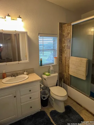 a bathroom with a double vanity sink toilet and mirror