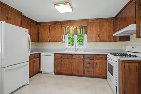 a kitchen with stainless steel appliances granite countertop a refrigerator sink and stove