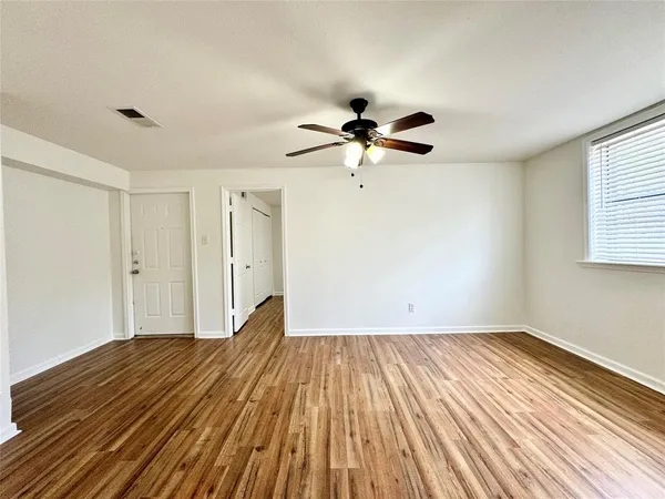a view of a livingroom with wooden floor and a ceiling fan