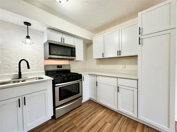 a kitchen with stainless steel appliances a refrigerator stove and microwave