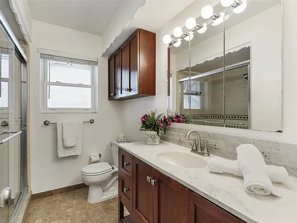 a bathroom with a sink vanity granite and toilet