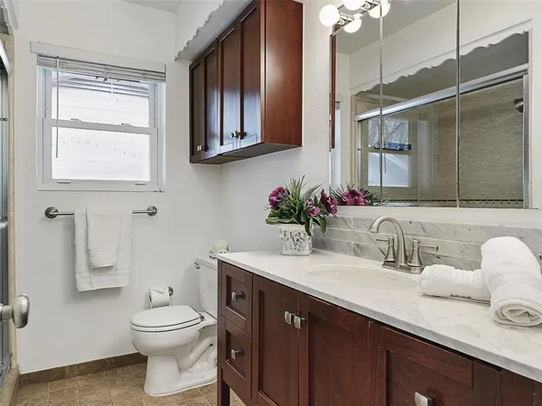 a bathroom with a sink vanity granite and toilet