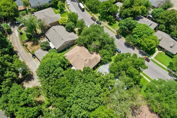 an aerial view of residential house with outdoor space and trees all around