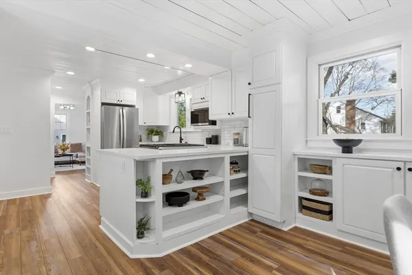 a kitchen with stainless steel appliances a stove a sink and a refrigerator with wooden floor