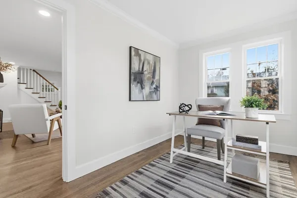 a work room with furniture wooden floor and a window