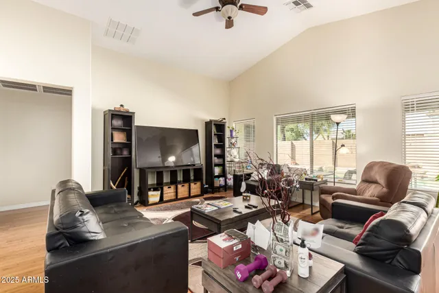 a living room with furniture a flat screen tv and a window