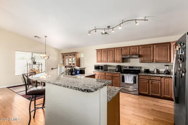a kitchen with stainless steel appliances granite countertop refrigerator stove microwave and cabinets