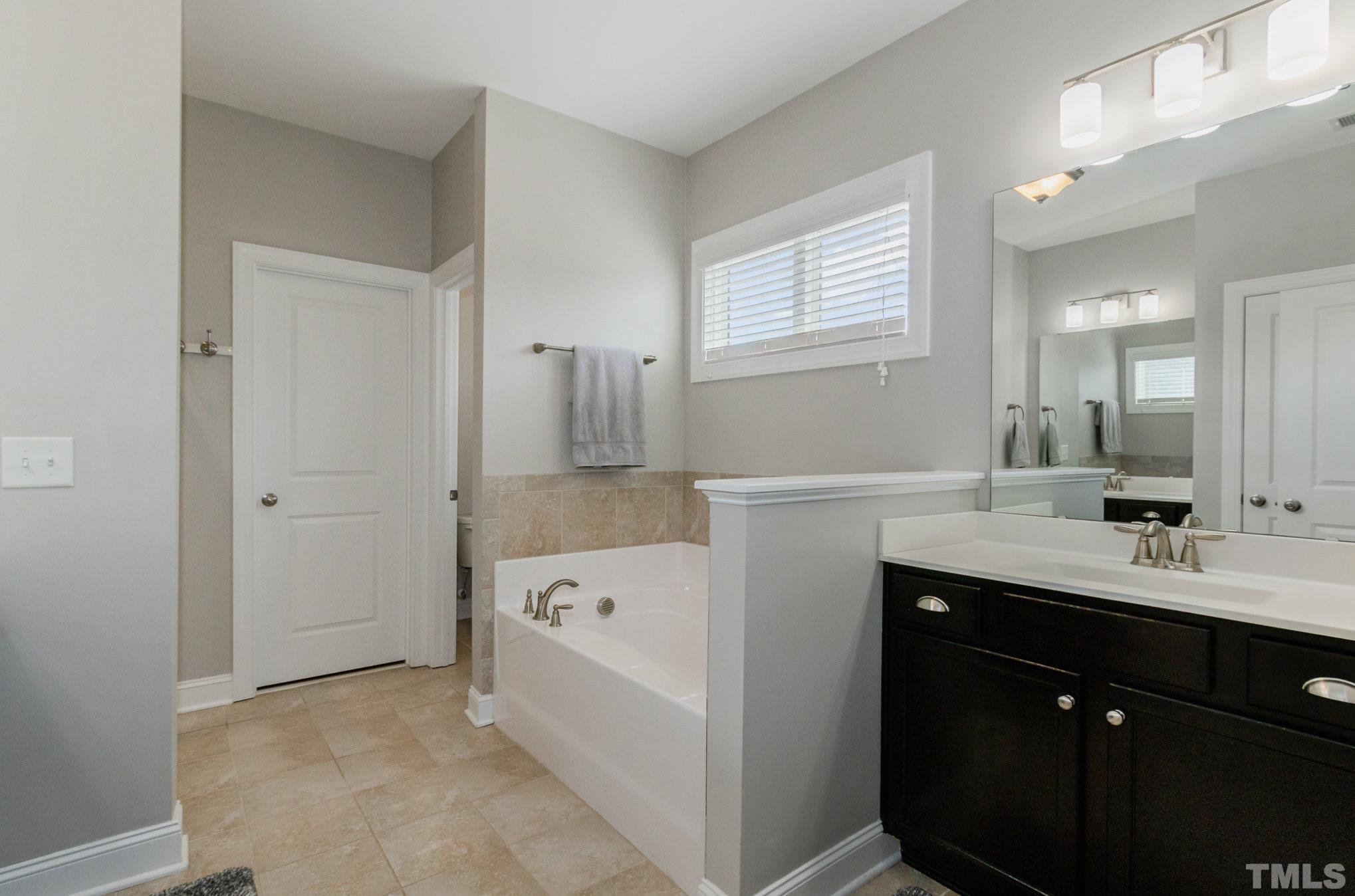 428 Seabring Lane Raleigh, NC 27603 - Photo 21 of 40 primary bath with separate vanities, separate tub and shower and large walk in closet.