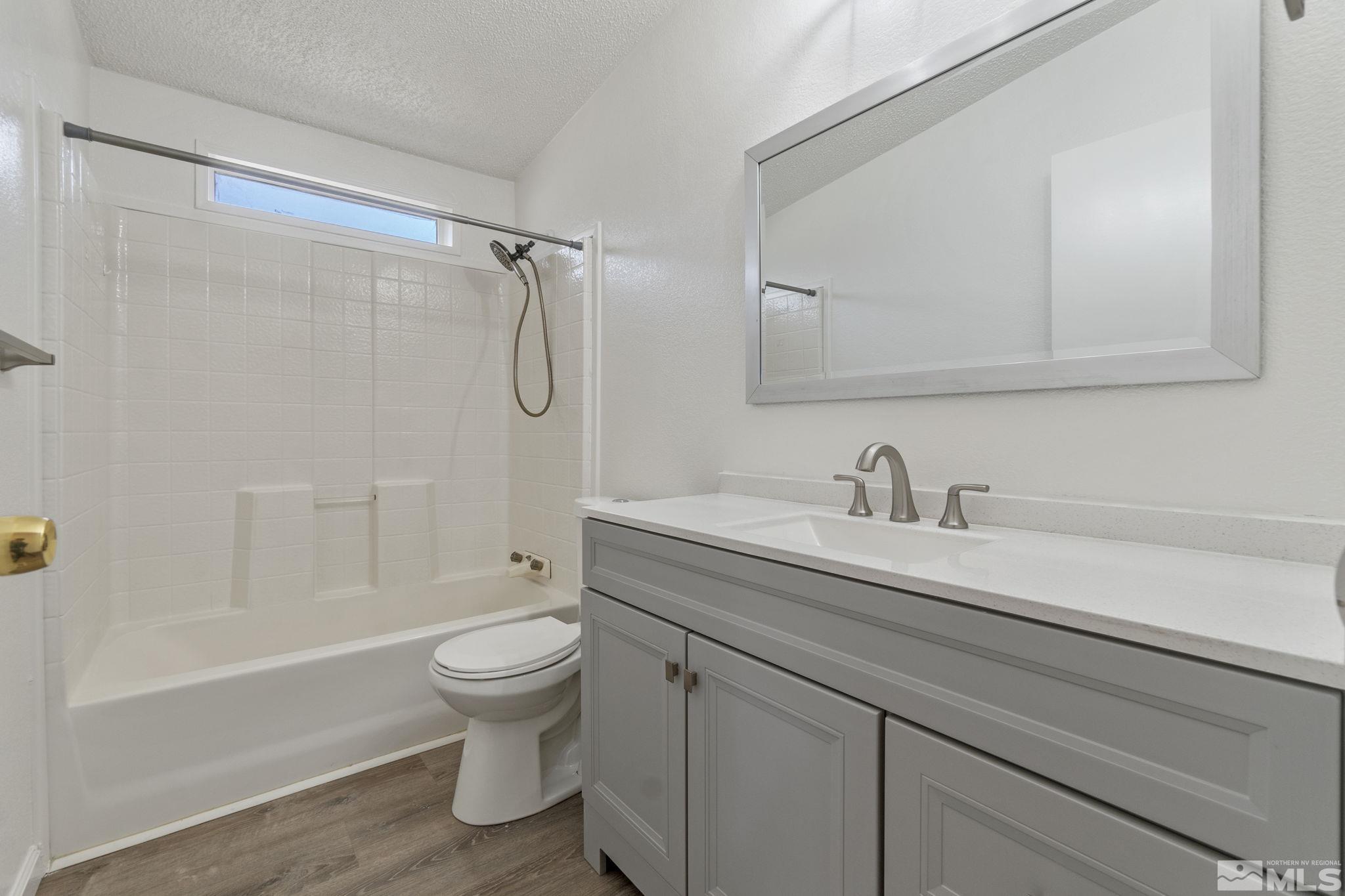 15015 Kivett Lane Reno, NV 89521 - Photo 26 of 37 a bathroom with a granite countertop sink a toilet and a bathtub