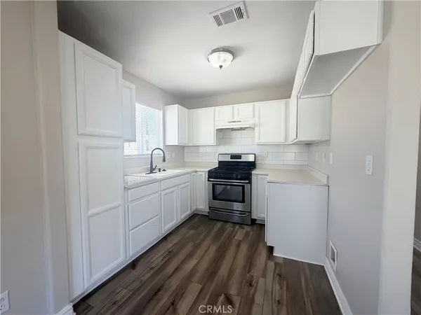 a kitchen with sink a microwave and cabinets