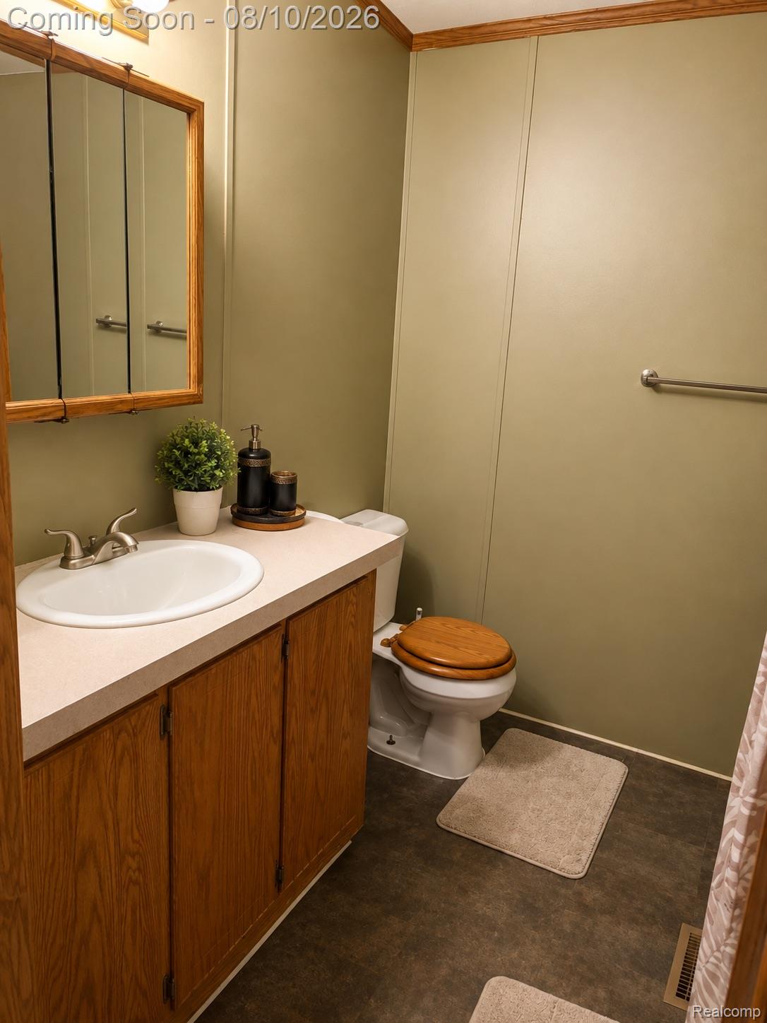 3730 Lapeer Road Port Huron, MI 48060 - Photo 12 of 18 Vanity with an integrated sink, wood-finish cabinetry, and a framed mirror