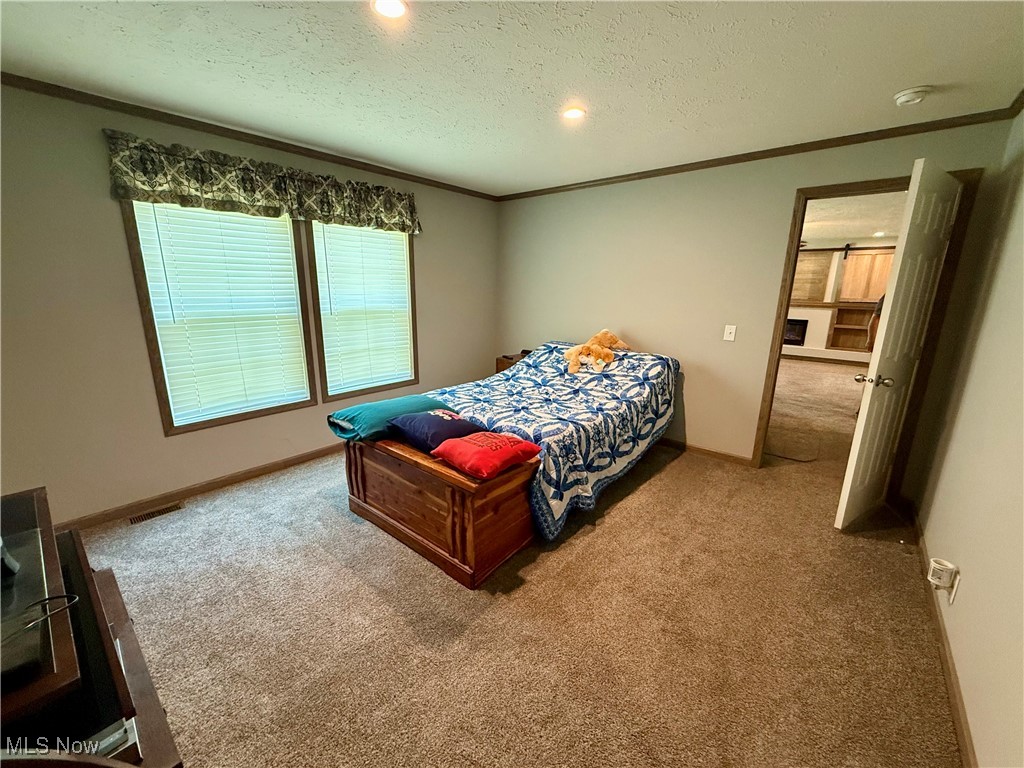 2306 Gordon Road Northwest Dover, OH 44622 - Photo 15 of 26 Bedroom with carpet, ornamental molding, recessed lighting, and a textured ceiling