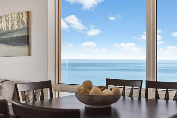 a living room with furniture floor to ceiling window and a flat screen tv