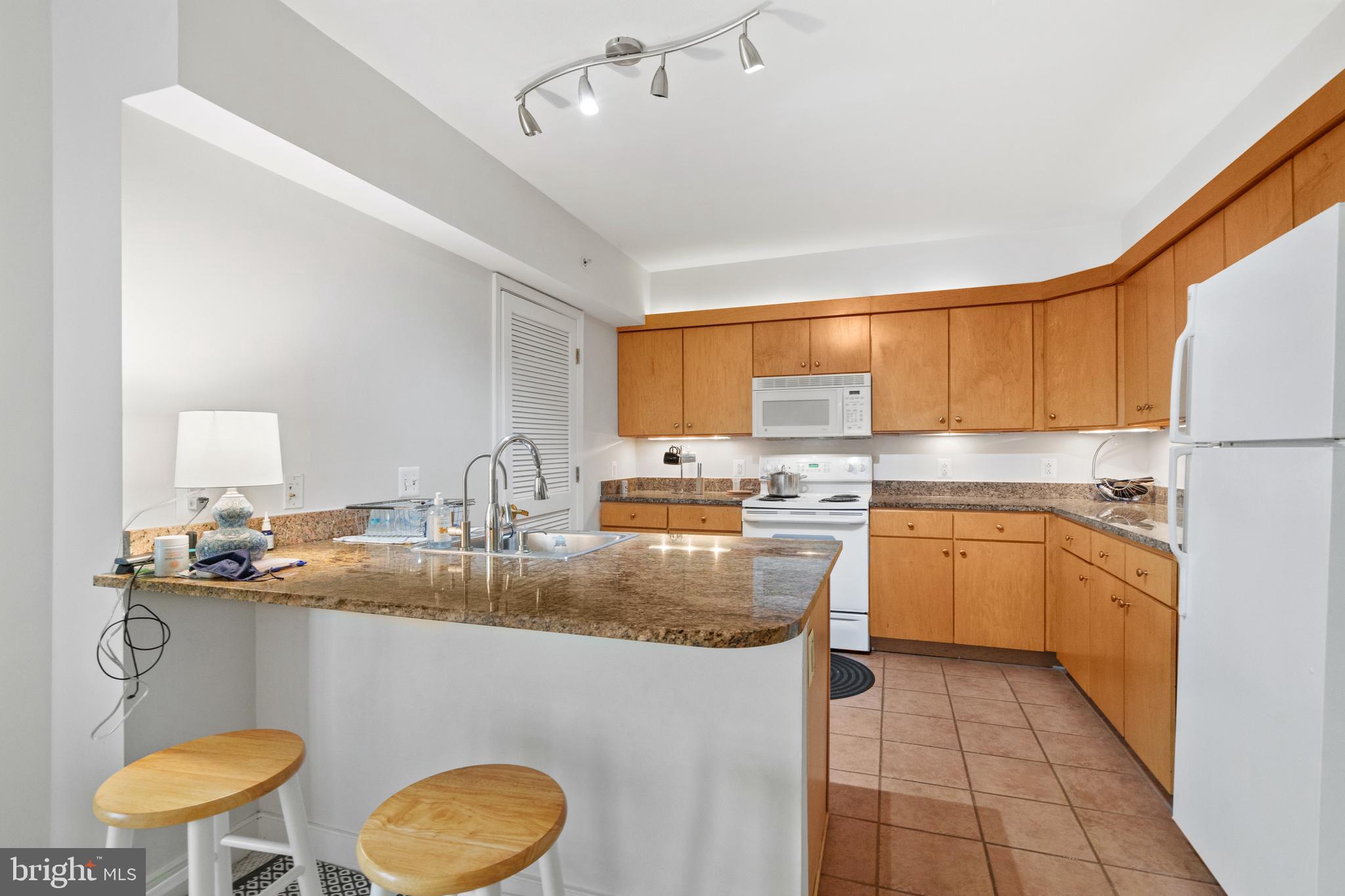 616 E Street Northwest, Unit 304 Washington, DC 20004 - Photo 18 of 53 a kitchen with kitchen island granite countertop a sink cabinets and window