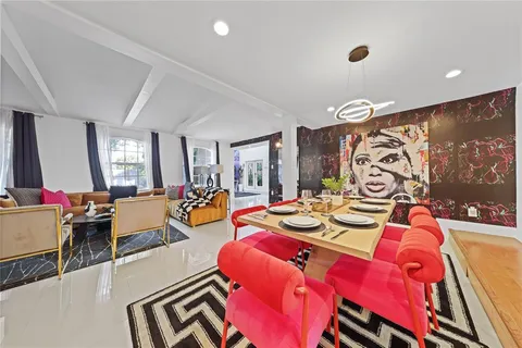 a living room with patio furniture and a flat screen tv