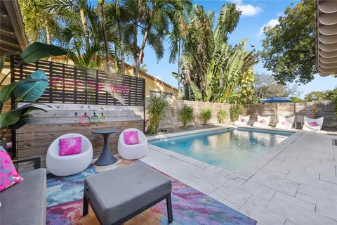 a view of a backyard with plants and a large tree