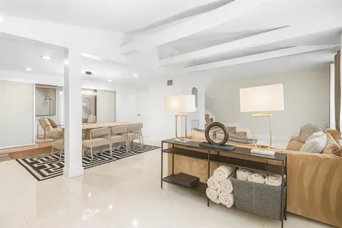 a living room with furniture a rug and white walls