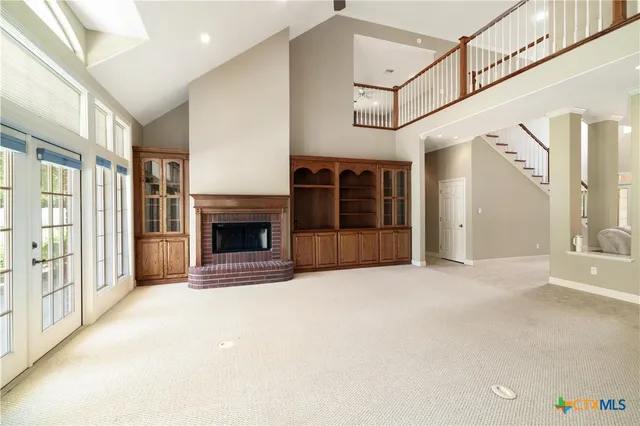 a view of an empty room with a fireplace and a window