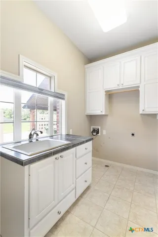 a kitchen with white cabinets and sink