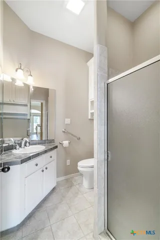 a bathroom with a granite countertop sink a toilet and a shower