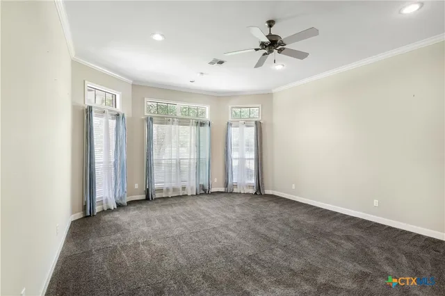 an empty room with fan and windows