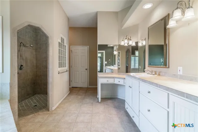 a spacious bathroom with a granite countertop sink mirror and shower