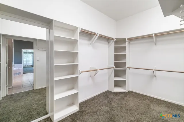 a view of walk in closet with empty racks