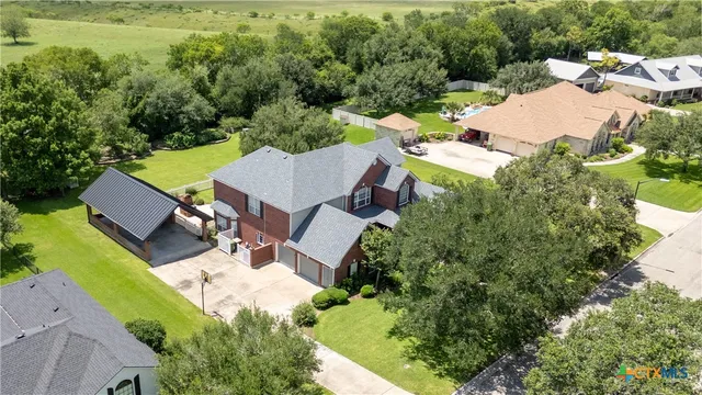 an aerial view of a house with garden space and street view