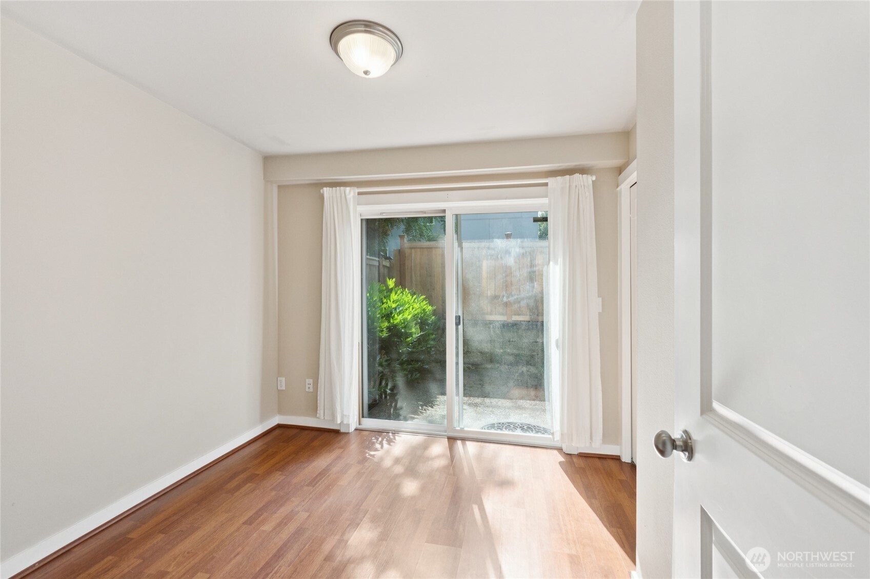 9503 Ashworth Avenue North, Unit B Seattle, WA 98103 - Photo 3 of 26 an empty room with wooden floor and windows