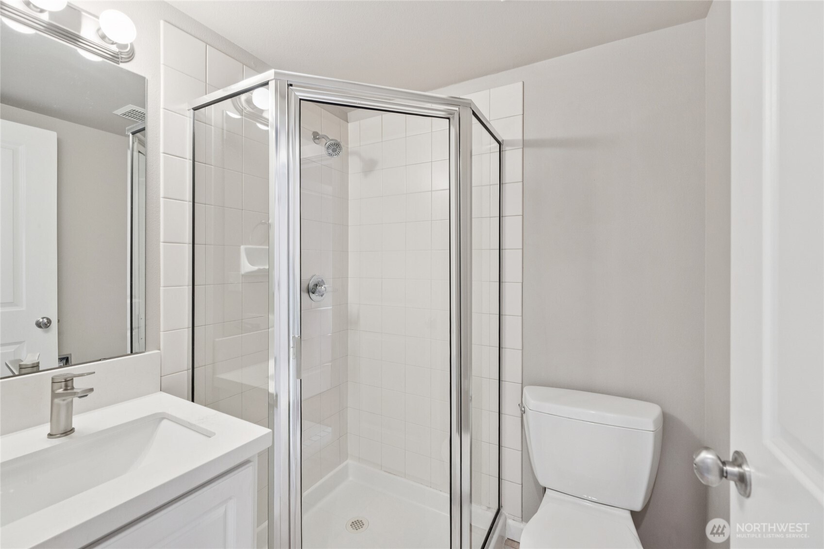 9503 Ashworth Avenue North, Unit B Seattle, WA 98103 - Photo 5 of 26 a bathroom with a shower sink vanity mirror and toilet