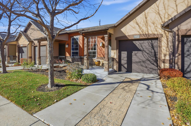 14820 175 East Draper, UT 84020 - Photo 32 of 39 View of front facade with driveway, stucco siding, a porch, a front yard, and an attached garage