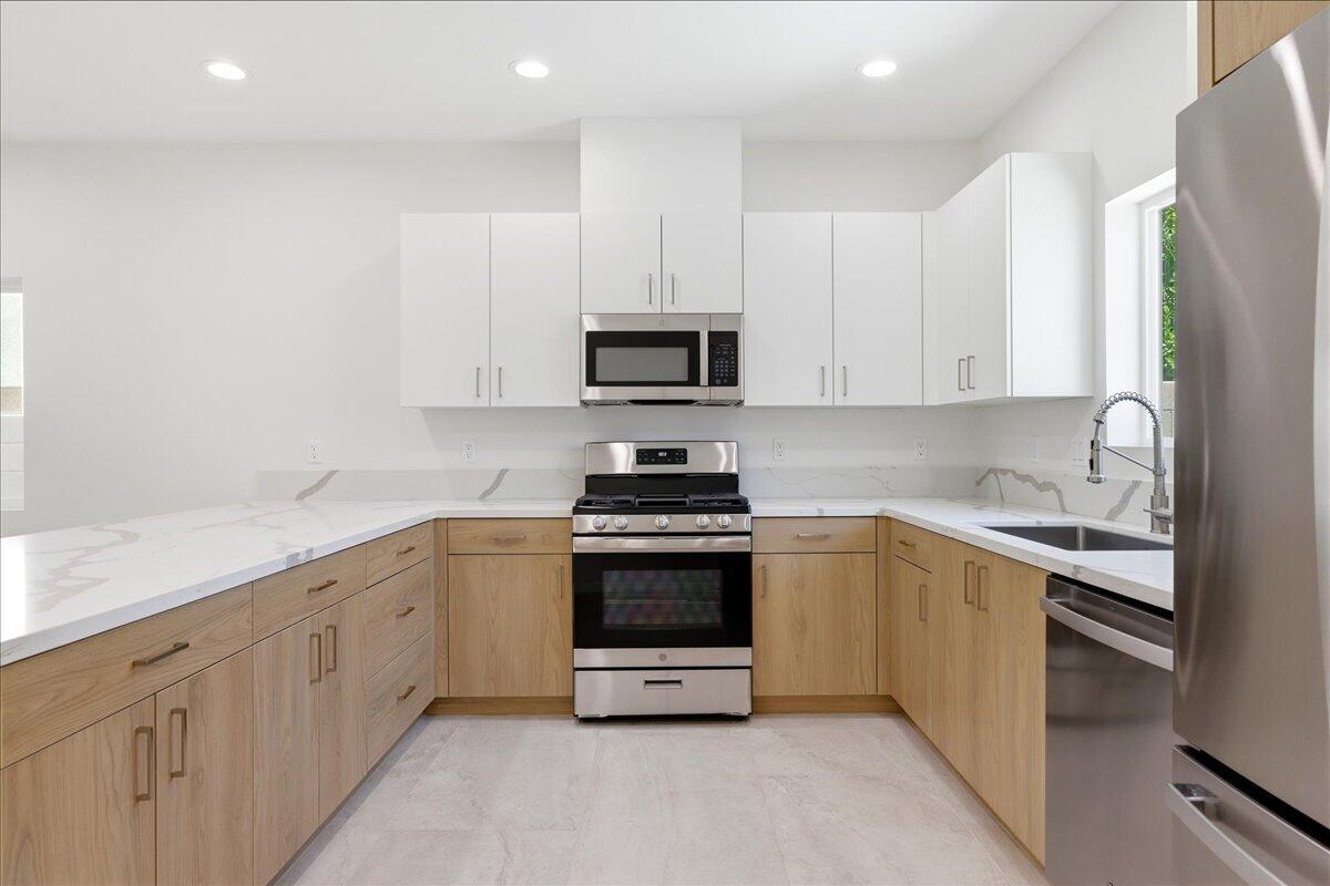 68160 Modalo Road Cathedral City, CA 92234 - Photo 12 of 57 a kitchen with granite countertop white cabinets and stainless steel appliances
