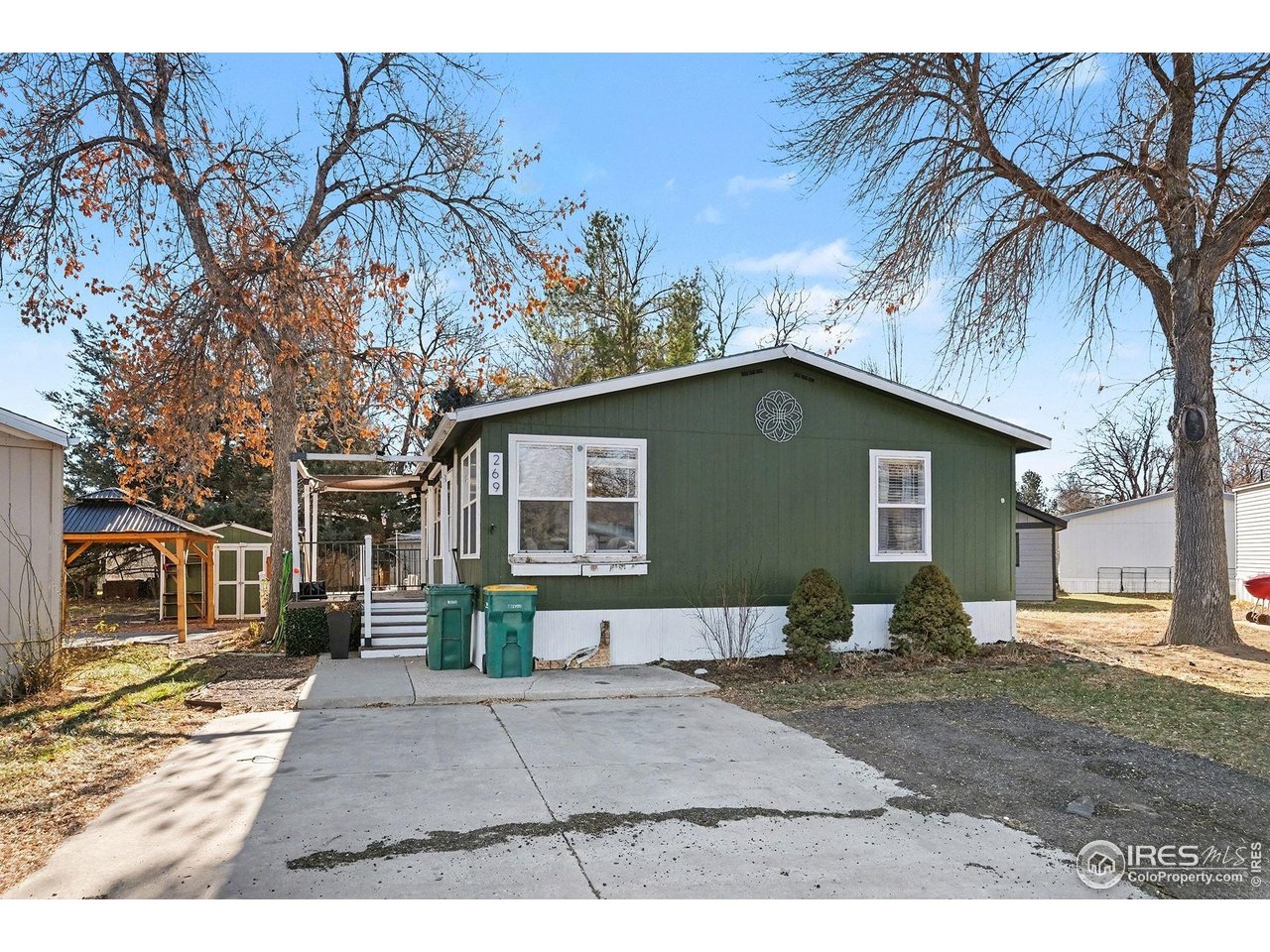 a backyard of a house with large trees and barbeque oven