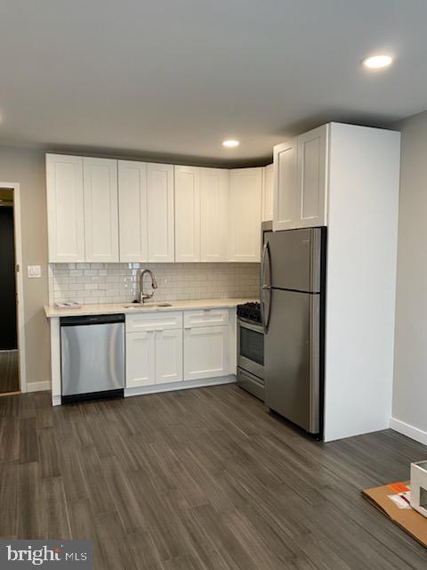a kitchen with a refrigerator and white cabinets