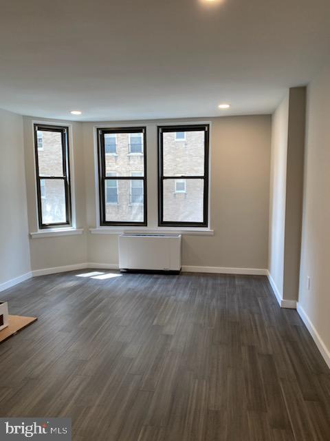 135 South 19th Street, Unit 1007 Philadelphia, PA 19103 - Photo 2 of 13 an empty room with wooden floor and windows
